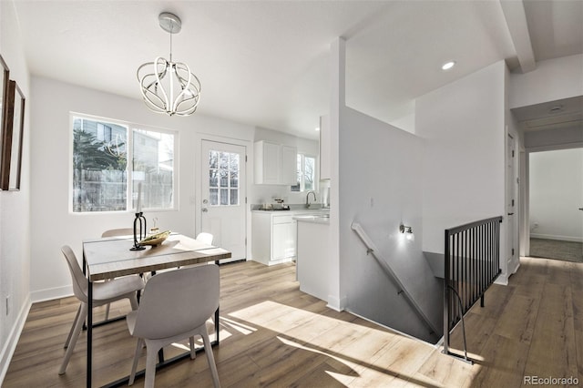 dining space featuring a chandelier, recessed lighting, baseboards, light wood-type flooring, and beamed ceiling