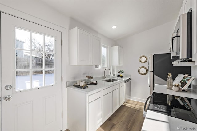 kitchen featuring light countertops, appliances with stainless steel finishes, a sink, and white cabinetry