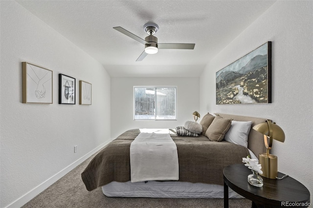 carpeted bedroom with a textured wall, a ceiling fan, vaulted ceiling, a textured ceiling, and baseboards