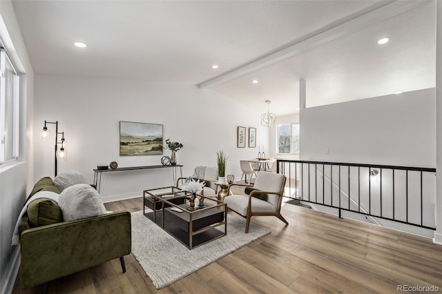 living room with lofted ceiling with beams, light wood finished floors, a chandelier, and recessed lighting