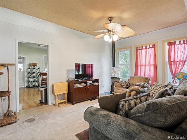 living area featuring a ceiling fan and carpet flooring