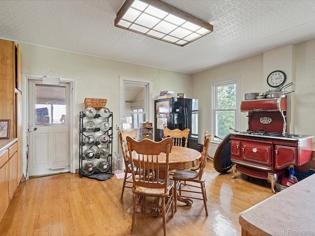 dining area featuring a textured ceiling and light wood-style flooring