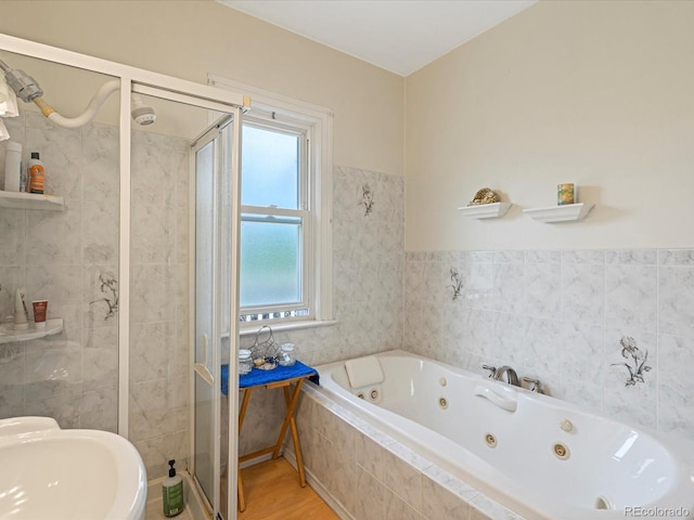 full bath featuring tile walls, a sink, a shower stall, wood finished floors, and a jetted tub