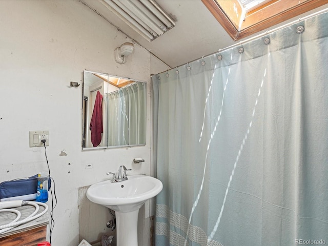 full bath with curtained shower and a sink