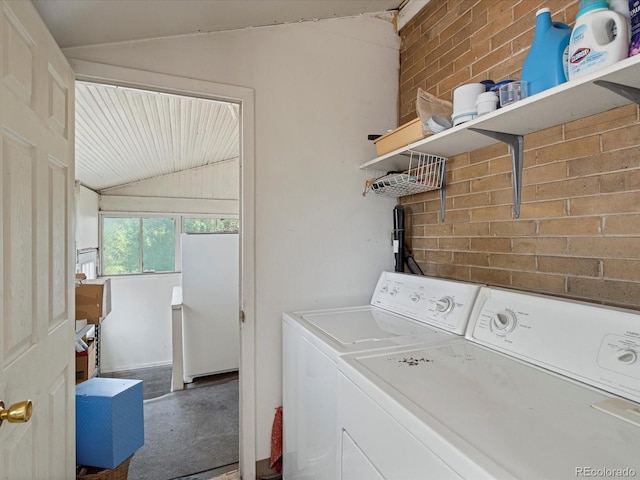 clothes washing area with laundry area, independent washer and dryer, and brick wall