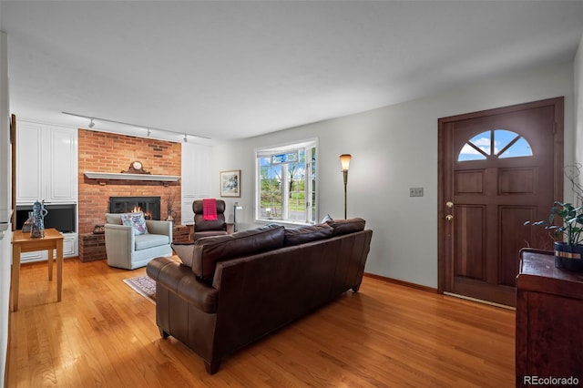 1322 Wicklow St, Boulder, CO 80303 - living room with track lighting, light wood-style floors, a fireplace, and baseboards
