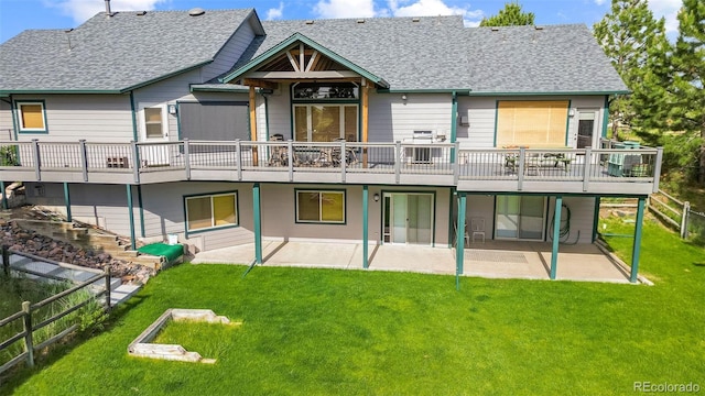 rear view of property featuring a deck, a patio area, and a yard