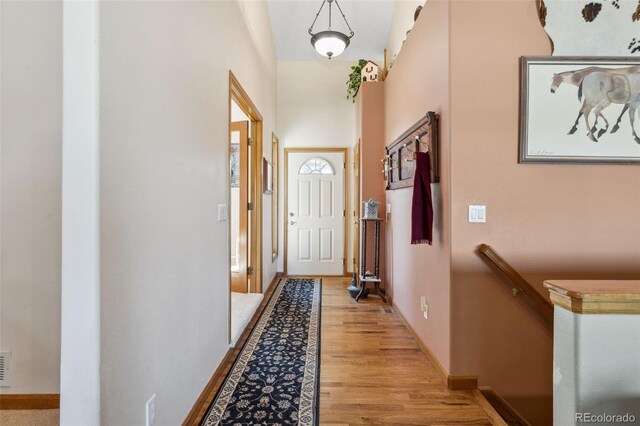 doorway to outside featuring light wood finished floors and baseboards