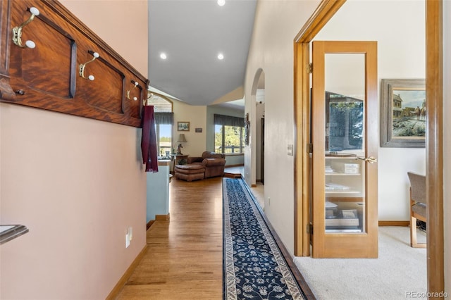 corridor featuring light hardwood / wood-style floors and lofted ceiling