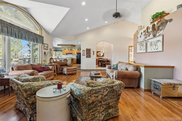 living room featuring arched walkways, recessed lighting, ceiling fan, high vaulted ceiling, and light wood-type flooring