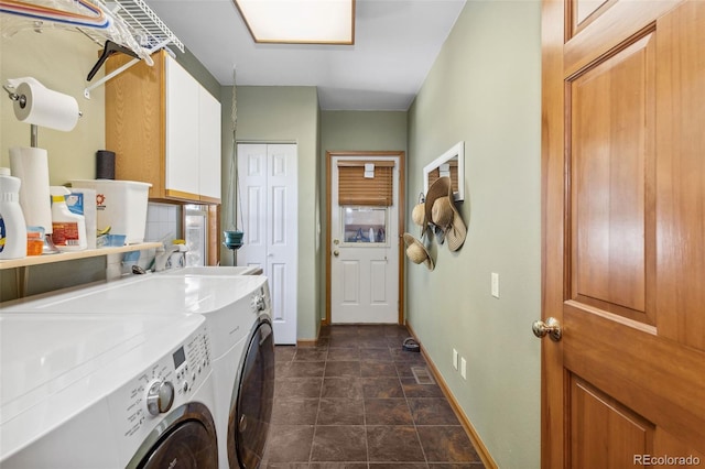 clothes washing area featuring washer and dryer and cabinets