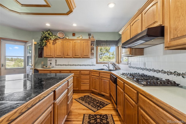 kitchen with a healthy amount of sunlight, stainless steel gas stovetop, sink, and light hardwood / wood-style floors