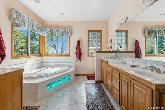 full bath featuring a sink, double vanity, tile patterned flooring, and a garden tub