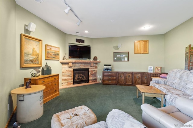 living room with rail lighting, dark carpet, and a fireplace