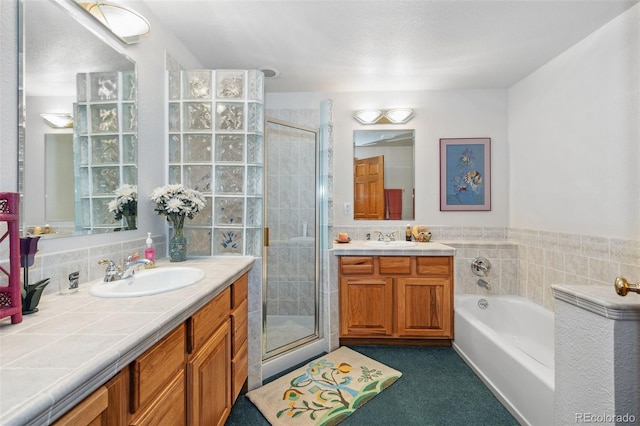 full bathroom featuring a stall shower, a garden tub, and a sink