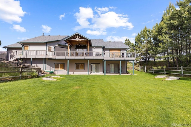 back of property featuring a wooden deck and a yard