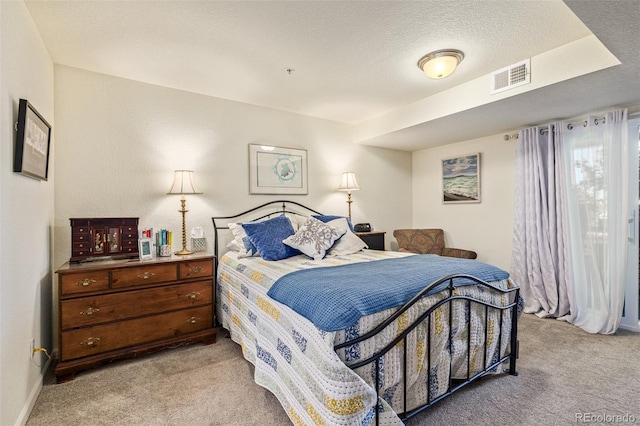 bedroom featuring light carpet and a textured ceiling