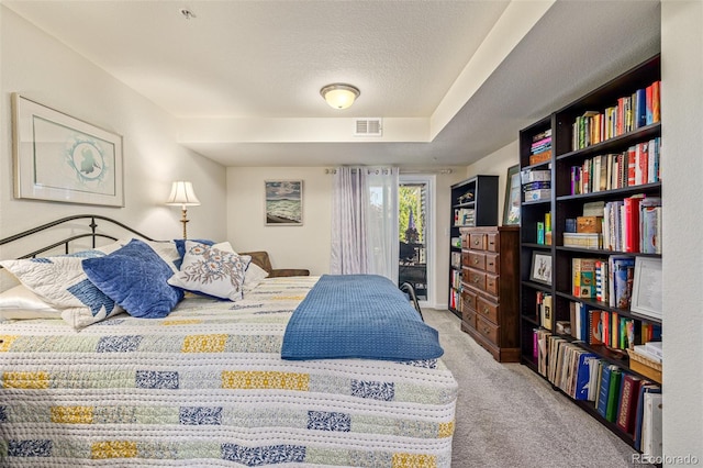 carpeted bedroom with a textured ceiling and access to exterior