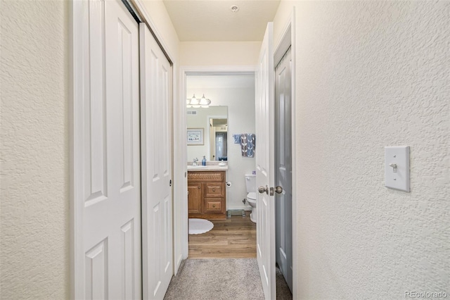 hallway with sink and light hardwood / wood-style flooring