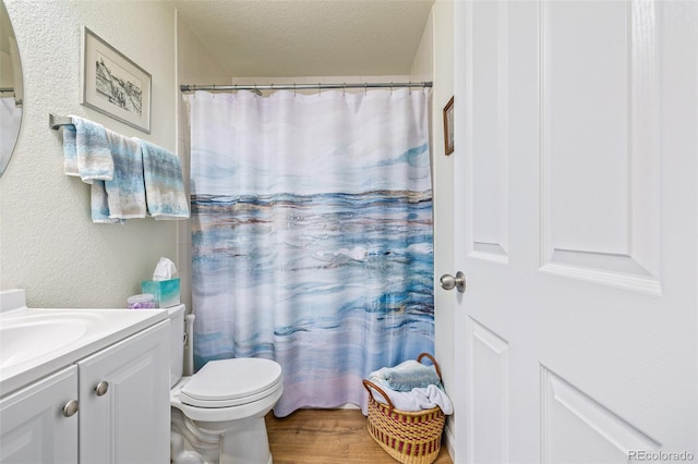 bathroom with vanity, toilet, a textured ceiling, and a shower with curtain