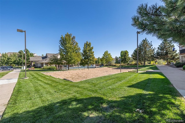 view of home's community featuring a lawn and volleyball court