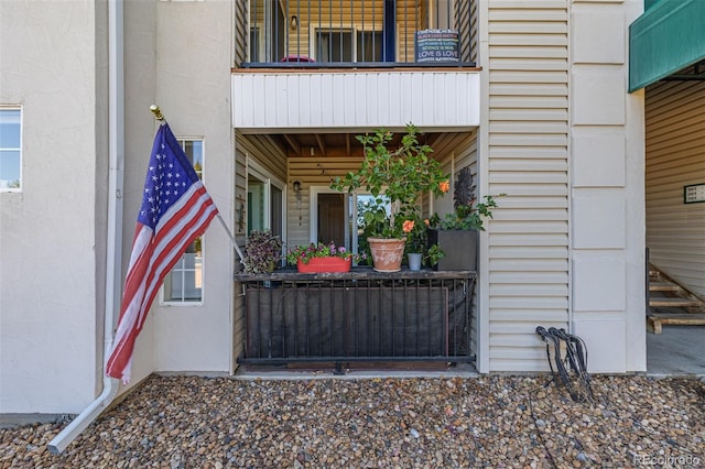 view of exterior entry with a balcony