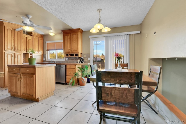 kitchen with pendant lighting, light tile patterned floors, dishwasher, ceiling fan, and decorative backsplash