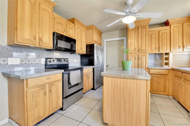 kitchen featuring stainless steel appliances, light tile patterned flooring, a center island, and light brown cabinets