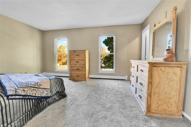 bedroom with multiple windows, a baseboard heating unit, light carpet, and a textured ceiling