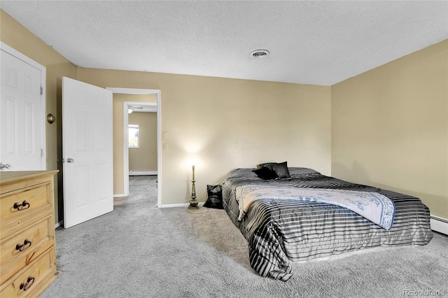 bedroom with a baseboard radiator, carpet flooring, and a textured ceiling