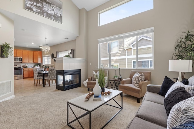 15125 E Bayaud Pl, Aurora, CO 80012 - living room featuring a high ceiling, a tile fireplace, light carpet, and recessed lighting