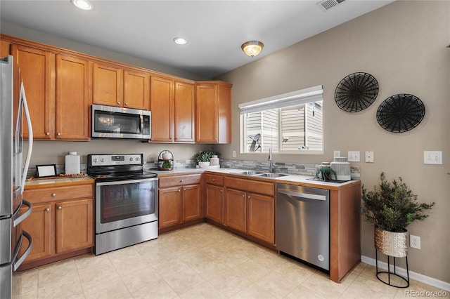15125 E Bayaud Pl, Aurora, CO 80012 - kitchen with stainless steel appliances, light countertops, brown cabinetry, and recessed lighting