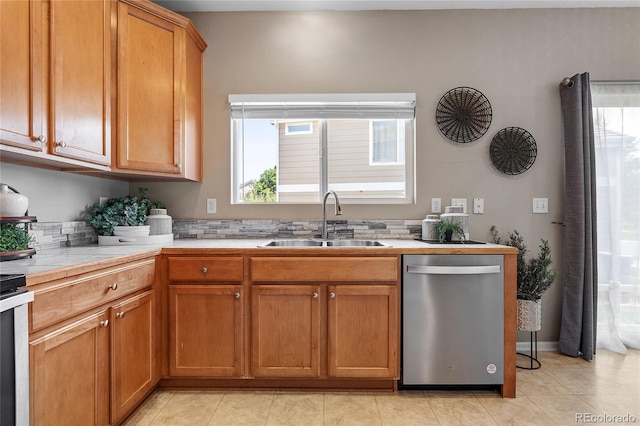 15125 E Bayaud Pl, Aurora, CO 80012 - kitchen featuring stainless steel dishwasher, light countertops, brown cabinetry, and light tile patterned floors