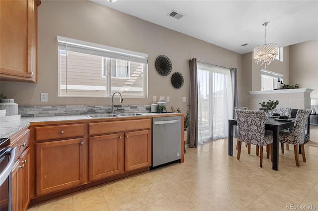 15125 E Bayaud Pl, Aurora, CO 80012 - kitchen featuring brown cabinets, a chandelier, dishwasher, stove, and decorative light fixtures