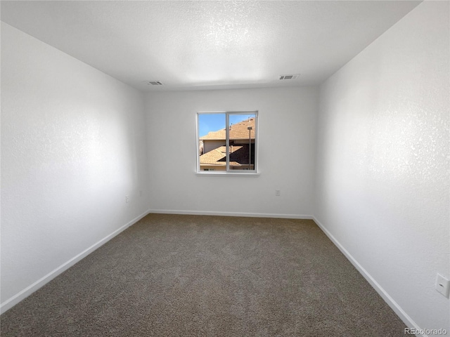 carpeted empty room with a textured ceiling