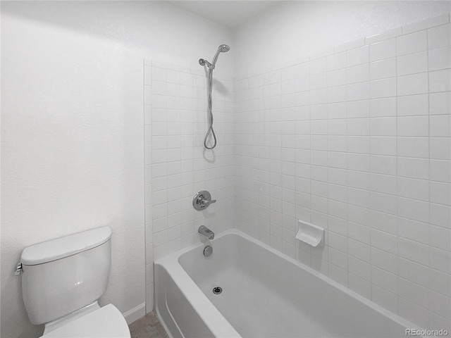 bathroom featuring toilet and tiled shower / bath