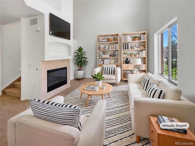 carpeted living room with a tile fireplace