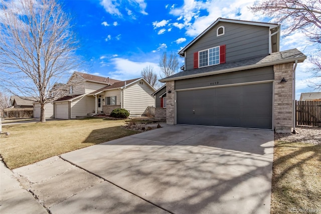 traditional-style home with a garage, concrete driveway, brick siding, and fence