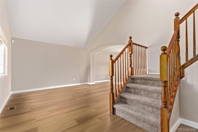 stairs with baseboards, visible vents, and wood finished floors