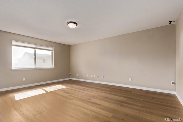 unfurnished room featuring light wood-style flooring and baseboards