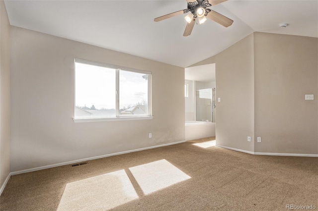 spare room with baseboards, visible vents, lofted ceiling, ceiling fan, and carpet flooring