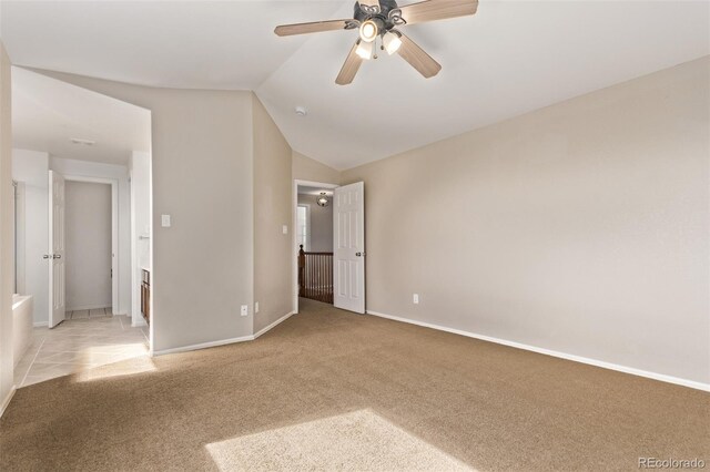 unfurnished bedroom featuring light carpet, ceiling fan, baseboards, and lofted ceiling