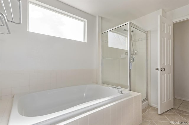 bathroom featuring a stall shower, a bath, and tile patterned floors