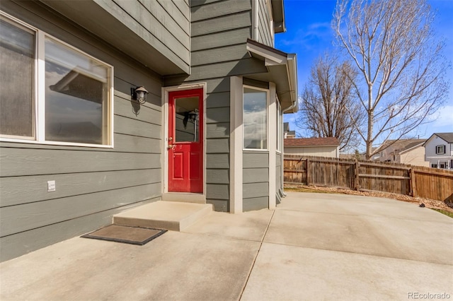 property entrance featuring a patio area and fence