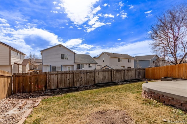 view of yard featuring a patio, a fenced backyard, and a residential view