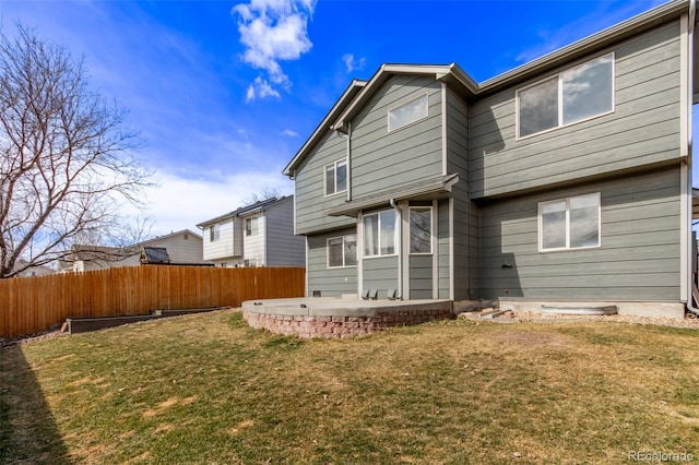 back of property with a yard, a patio area, and fence