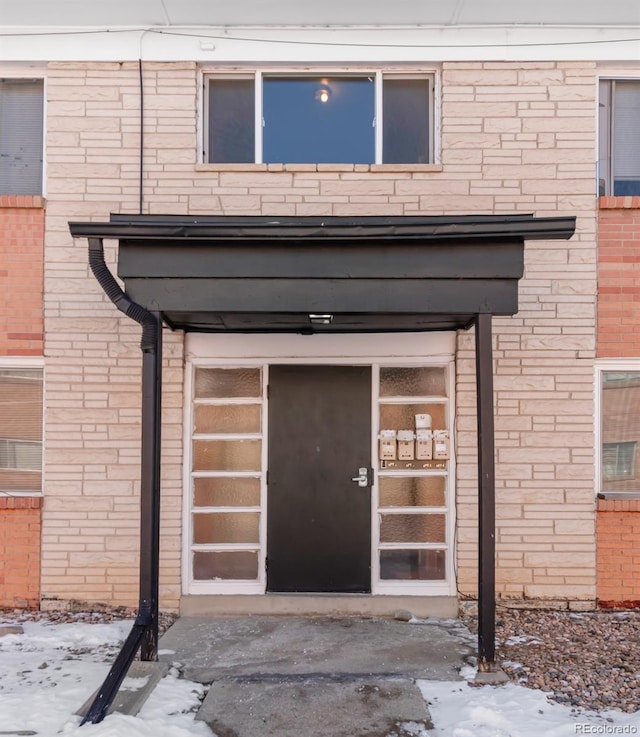 7100 Stuart St, Westminster, CO 80030 - snow covered property entrance featuring brick siding