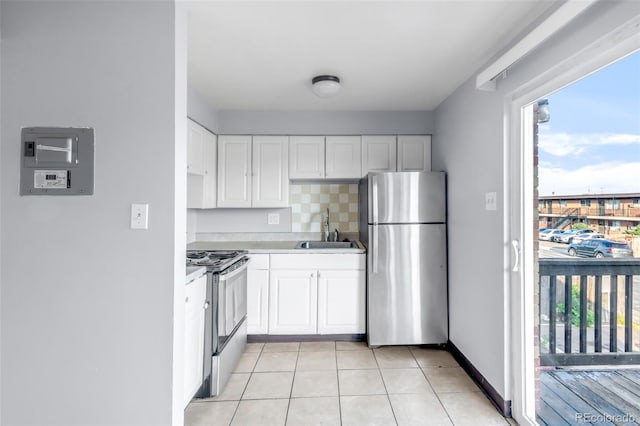 7100 Stuart St, Westminster, CO 80030 - kitchen featuring appliances with stainless steel finishes, white cabinets, light countertops, and light tile patterned flooring