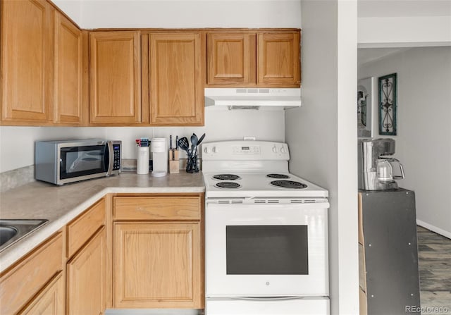 7100 Stuart St, Westminster, CO 80030 - kitchen with white range with electric cooktop, stainless steel microwave, under cabinet range hood, and light countertops