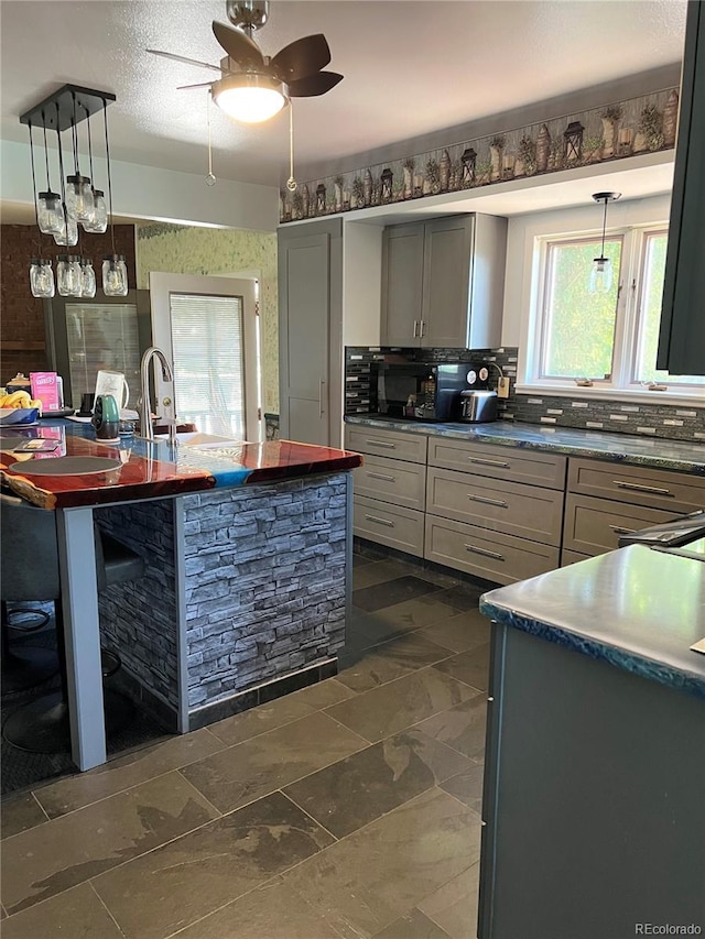 4307 Valli Vista Rd, Colorado Springs, CO 80915 - kitchen featuring gray cabinetry, hanging light fixtures, ceiling fan, and backsplash